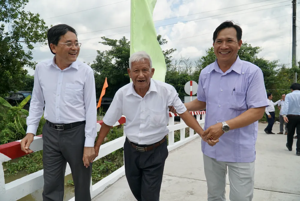 Các đại biểu trò chuyện cùng người dân trong ngày khánh thành cầu. Ảnh: BẢO PHƯƠNG