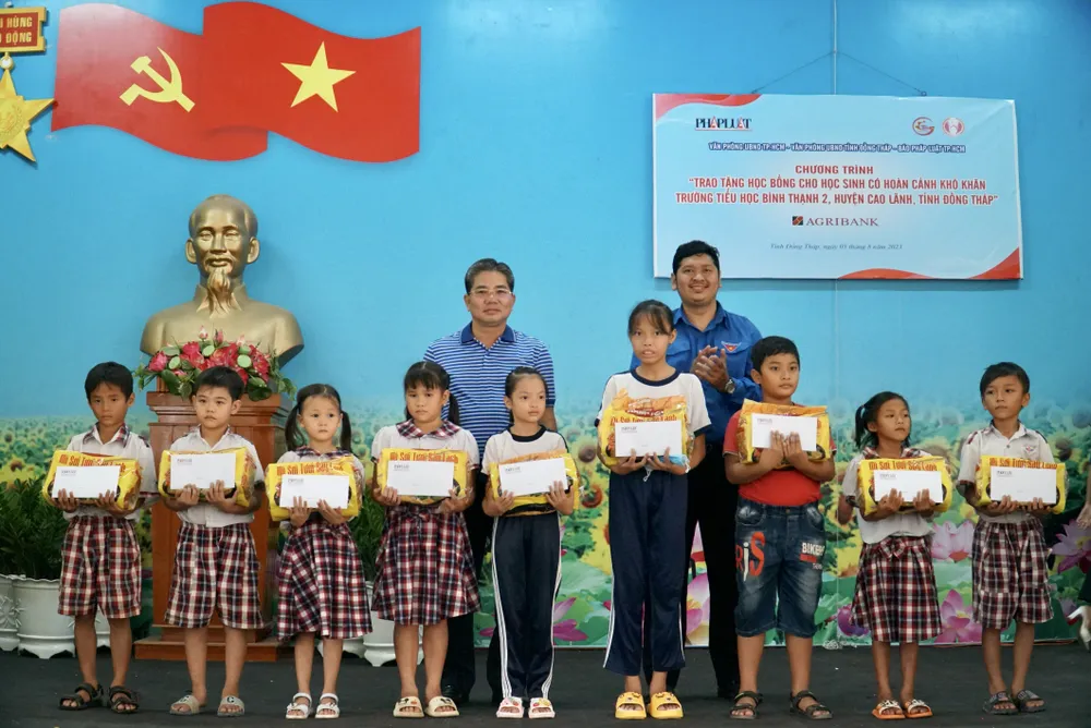 Ông Bùi Hữu Hồng Hải, Bí thư Đoàn Khối Dân - Chính - Đảng TP.HCM và ông Huỳnh Văn Minh, Phó Chủ tịch UBND huyện Cao Lãnh trao quà hỗ trợ các em học sinh. Ảnh: BẢO PHƯƠNG