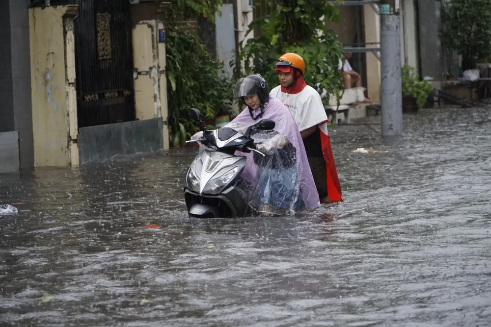 Người dân TP.HCM dắt xe qua đoạn ngập mỗi khi trời mưa lớn. Ảnh: D.Q