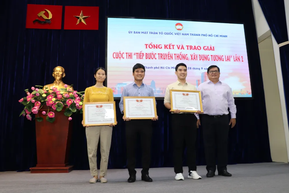 Phó Chủ tịch Uỷ ban MTTQ Việt Nam TP trao bằng khen cho hai giải nhì và giải nhất cuộc thi "Tiếp bước truyền thống, xây dựng tương lai" lần 2. Ảnh: BP tiep-buoc-truyen-thong-5.JPG
