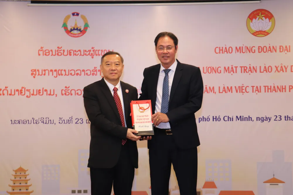 Ông Nguyễn Thành Trung tặng quà cho ông Ot Phongsavanh. Ảnh: PHƯƠNG ĐẶNG Đoàn đại biểu Trung ương Mặt trận Lào Xây dựng đất nước