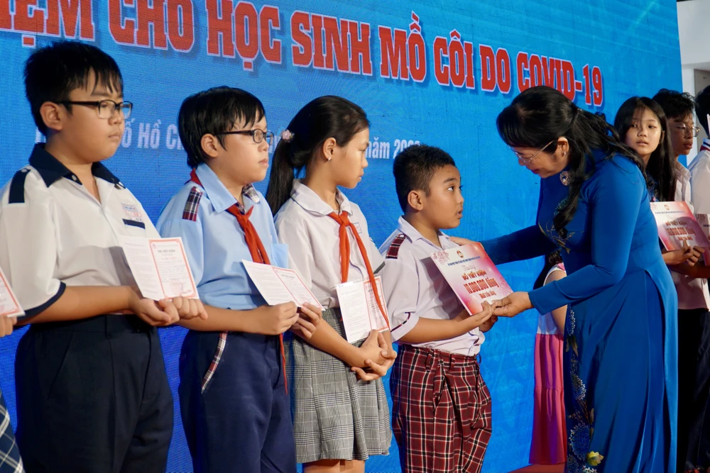 Chủ tịch Uỷ ban MTTQ Việt Nam TP Trần Kim Yến trao sổ tiết kiệm cho các em em học sinh. Ảnh: BẢO PHƯƠNG Quỹ An sinh xã hội
