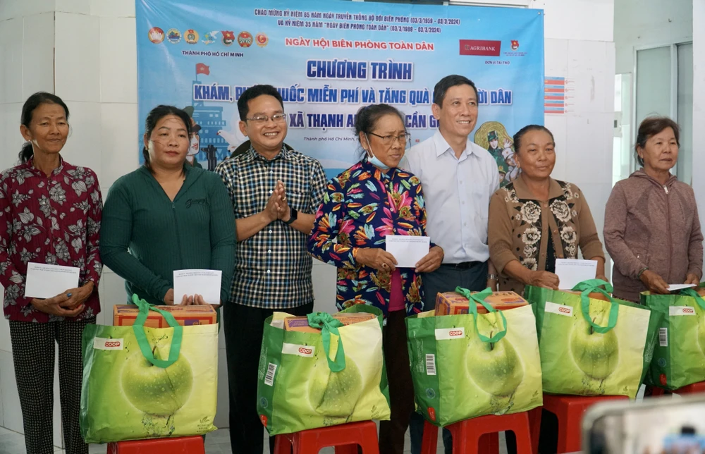 Phó Chủ tịch Uỷ ban MTTQ Việt Nam TP.HCM Phạm Minh Tuấn (thứ 3, bìa trái) tặng quà cho bà con xã đảo. Ảnh: BẢO PHƯƠNG xa-dao-thanh-an-1.JPG