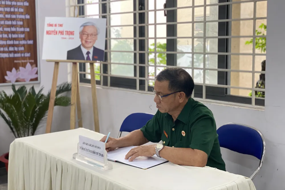 Ông Nguyễn Văn Minh (ngụ phường 9, quận Phú Nhuận) viết đôi dòng tưởng niệm Tổng Bí thư. Ảnh: BẢO PHƯƠNG tong-bi-thu-nguyen-phu-trong-8.jpg