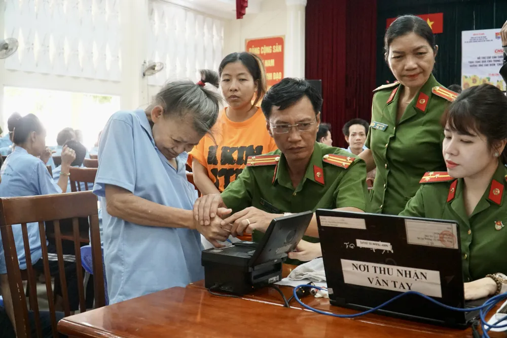 Cán bộ lấy dấu vân tay để làm thẻ Căn cước. Ảnh: BẢO PHƯƠNG the-can-cuoc-3.JPG