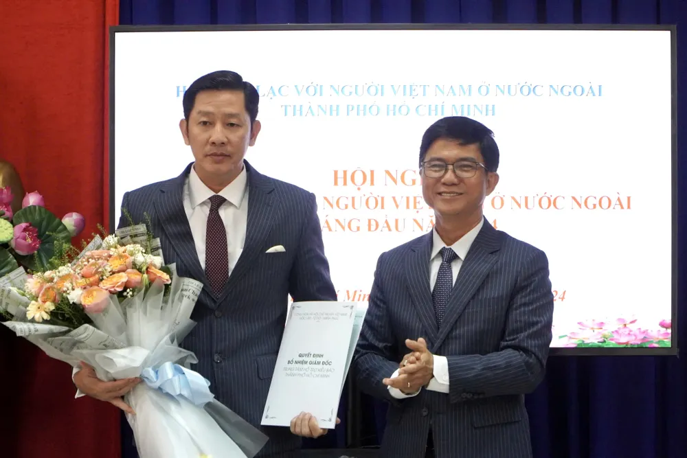 Ông Lê Văn Thu, Chủ tịch Hội Liên lạc với người Việt Nam ở nước ngoài TP.HCM, trao quyết định cho ông Lâm Quang Quý. Ảnh: BẢO PHƯƠNG Trung tâm Hỗ trợ kiều bào