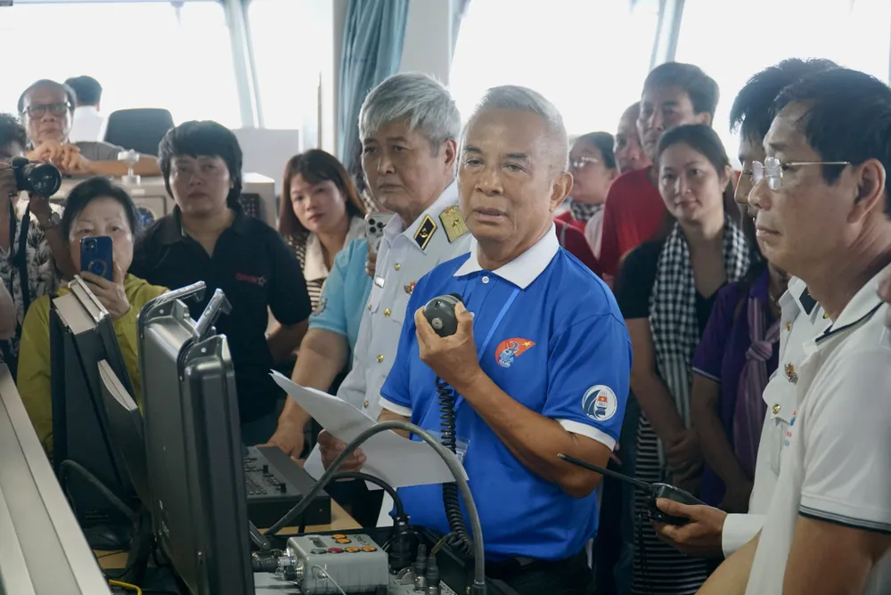 Ông Đặng Ngọc Tùng trò chuyện với các chiến sĩ Nhà giàn DKI/10 qua bộ đàm. Ảnh: BẢO PHƯƠNG doan-cong-tac-tay-nam-2.JPG