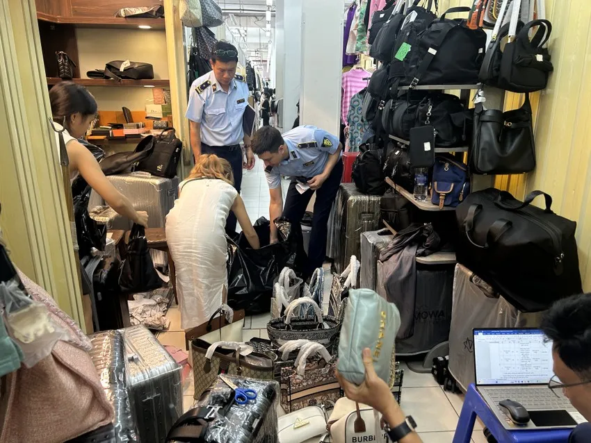 Lực lượng chức năng kiểm tra, phát hiện và tạm giữ hàng nghìn sản phẩm nghi giả mạo nhãn hiệu của các tiểu thương Saigon Square, ngày 29-5. Ảnh: HỒNG THẮM tieu-thuong-saigon-square-2.jpeg