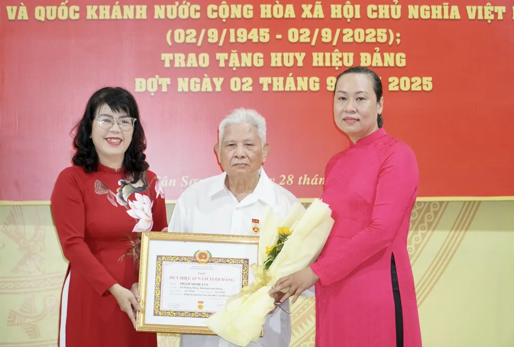Lãnh đạo phường Tân Sơn Hoà trao Huy hiệu Đảng cho các đảng viên cao tuổi. Ảnh: BẢO PHƯƠNG