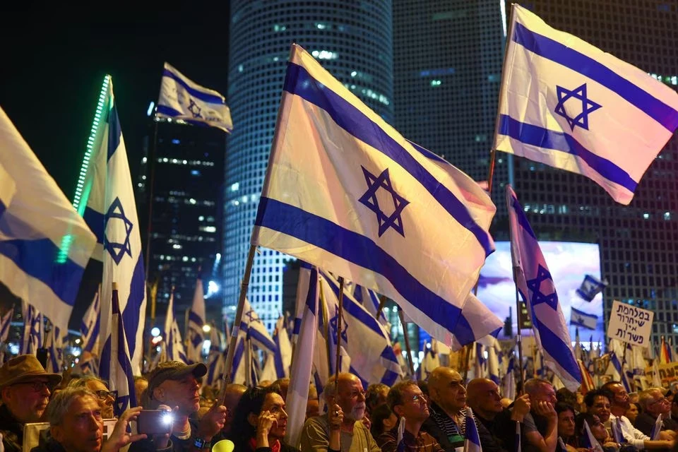 Người biểu tình cầm theo cờ Israel. Ảnh: REUTERS