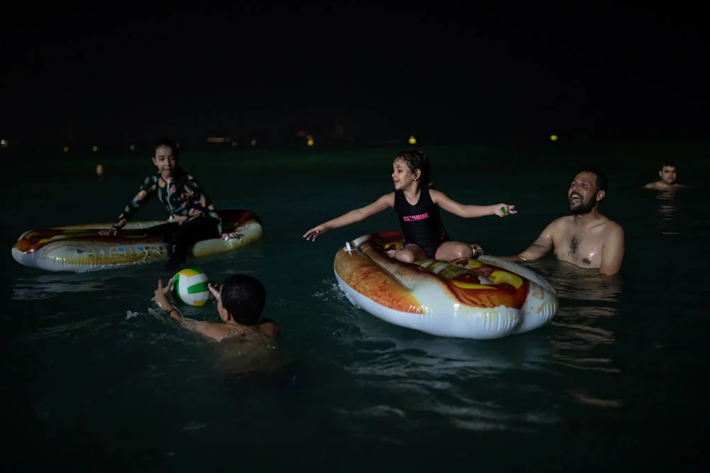 Du khách tại một bãi biển đêm ở Dubai (Các Tiểu vương quốc Ả Rập Thống nhất). Ảnh: THE NEW YORK TIMES