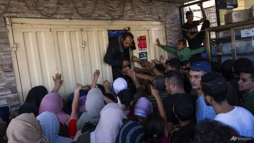Người dân tập trung trước một cửa hàng bánh mì tại Dải Gaza hôm 15-10. Ảnh: AP israel_palestinians_daily_photo_gallery_93066.jpg