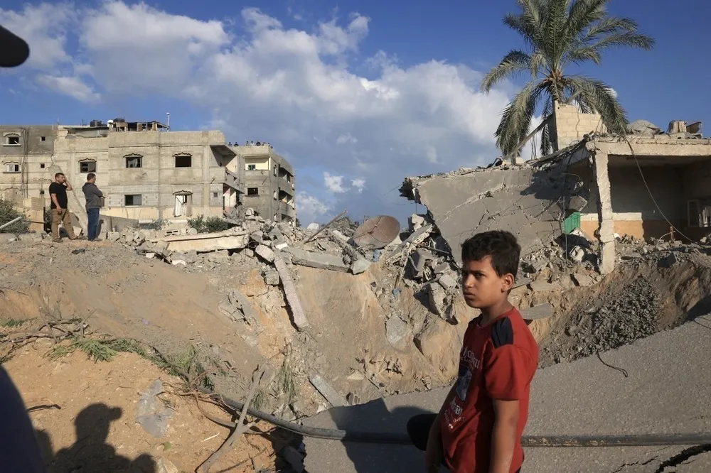 Một trẻ em tại Dải Gaza đứng bên đống đổ nát sau trận không kích của lực lượng Israel vào ngày 16-10. Ảnh: AFP 001_hero_oct16.jpg