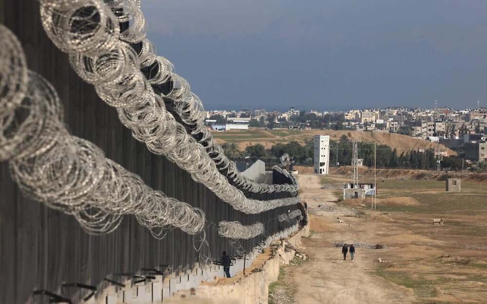 Người dân đi dọc bức tường giữa Gaza và Ai Cập ở phía nam Gaza. Ảnh: AFP xung-dot-Israel--Hamas-ngay-19-2-2024.jpg
