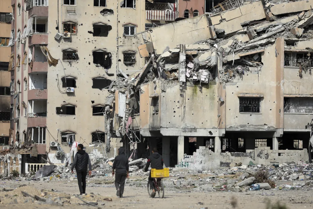 Người dân bắc Gaza đi qua khu vực đổ nát do các cuộc không kích của Israel. Ảnh: AP AP24041674132592.jpg