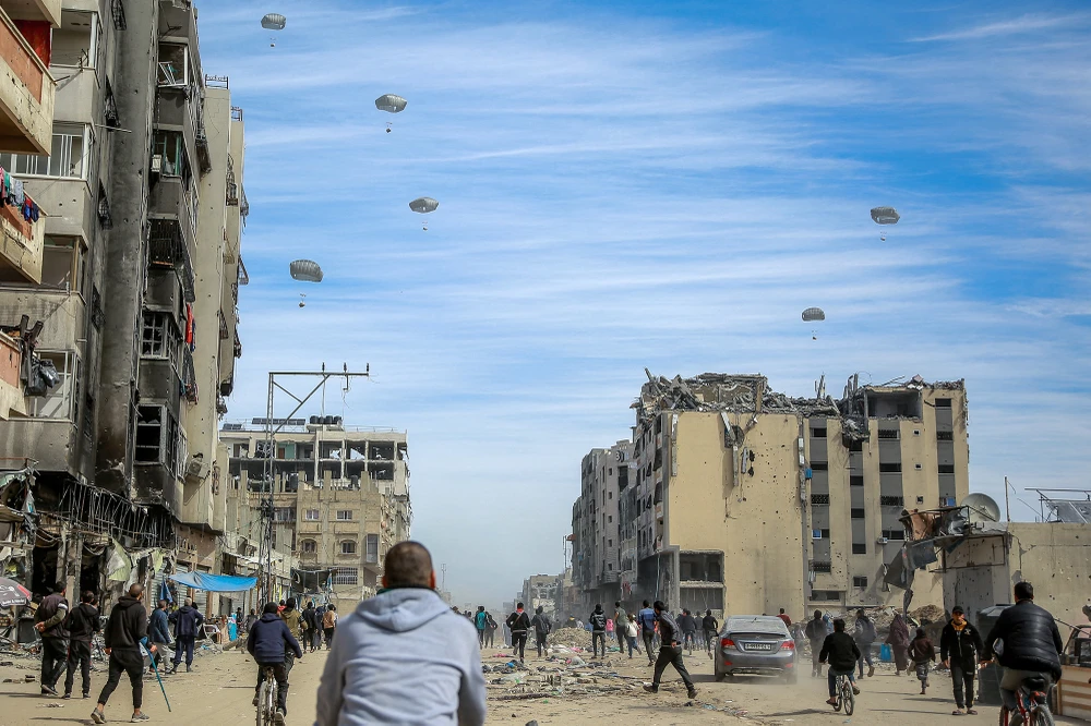 Người Palestine trên đường phố khi viện trợ nhân đạo được thả xuống TP Gaza hôm 1-3 trong bối cảnh xung đột Israel-Hamas đã bước sang ngày thứ 148. Ảnh: AFP xung-dot-Israel--Hamas-ngay-2-3-2024.jpg