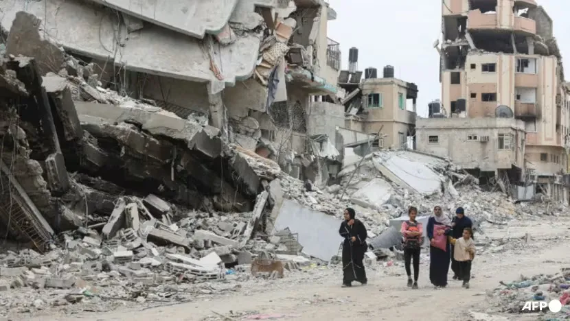 Người dân Gaza đi qua đống đổ nát sau cuộc tấn công của Israel tại TP Gaza (bắc Gaza). Ảnh: AFP 1f336faca166e7aec107c243b9b0b80a3c518902.jpg