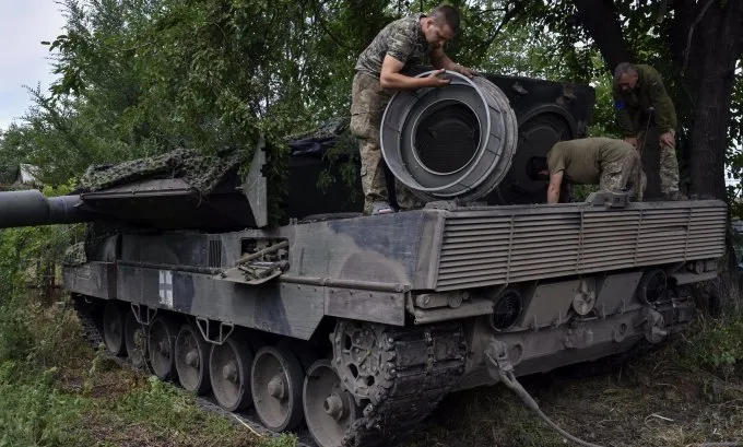 Binh sĩ Ukraine đang bảo dưỡng xe tăng chiến đấu chủ lực Leopard 2. Ảnh: AP Ukraine.jpg