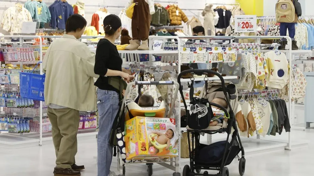 Khách hàng xem quần áo trẻ em tại một trung tâm mua sắm ở Kyoto (Nhật) vào tháng 10-2023. Ảnh: BLOOMBERG gettyimages-1740659778.webp