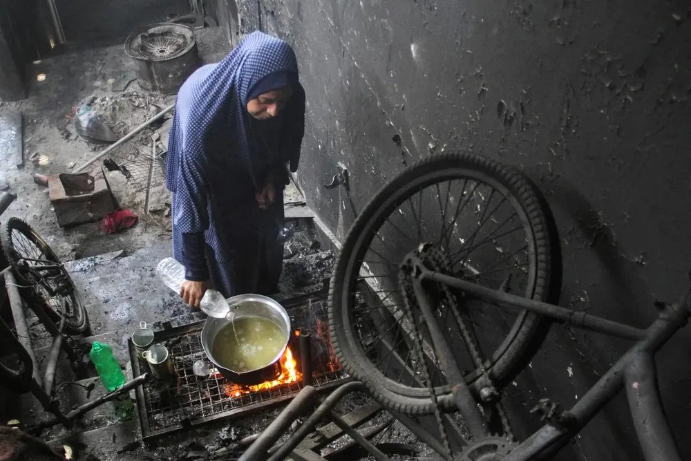 Người dân dùng nước nấu ăn tại trại tị nạn Jabalia (bắc Gaza). Ảnh: REUTERS 2024-06-12t094114z-1661724274-rc2078ax5jau-rtrmadp-3-israel-palestinians-jabalia-family-water.webp