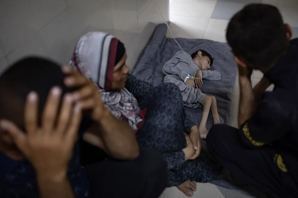 Một trẻ em nằm trên sàn nhà một bệnh viện tại Khan Younis. Ảnh: THE WALL STREET JOURNAL Cuoc-chien-o-Gaza.jpg
