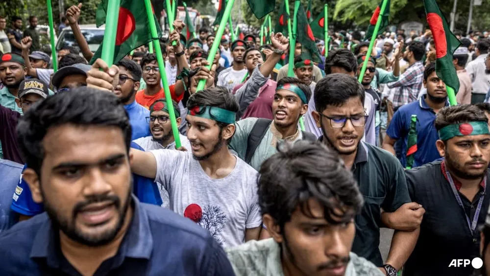 Người biểu tình cầm quốc kỳ Bangladesh đứng chặn tại Bảo tàng tưởng niệm Bangabandhu ở thủ đô Dhaka (Bangladesh) vào ngày 15-8-2024. Ảnh: AFP đụng dô phe biểu tình và phe ủng hộ cựu thủ tướng bangladesh.png