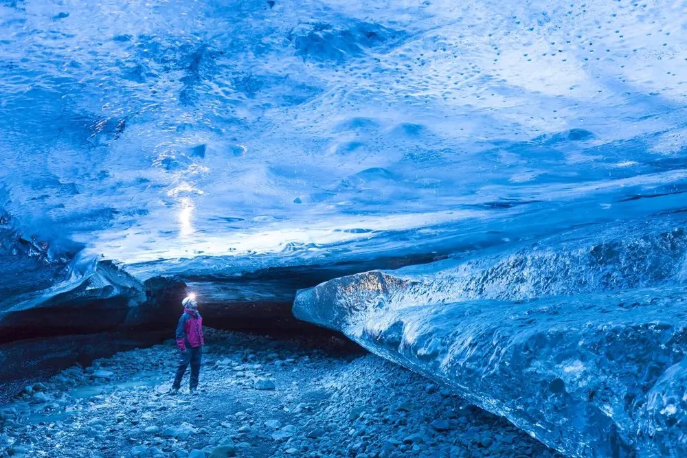 Du khách trong hang động băng, gần sông băng Breiðamerkurjökull (Iceland). Ảnh: GETTY IMAGES gettyimages-1749545793.webp