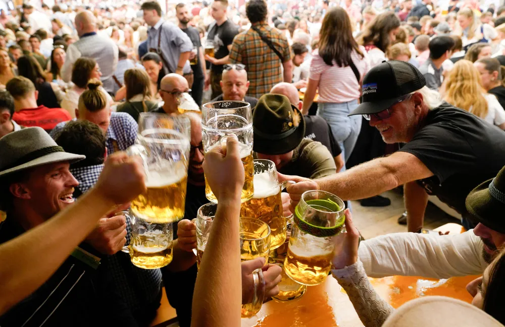 Du khách nâng cốc chúc mừng trong lễ hội bia lớn nhất thế giới Oktoberfest tại TP Munich (Đức). Ảnh: REUTERS lễ hội bia Oktoberfest 1.png