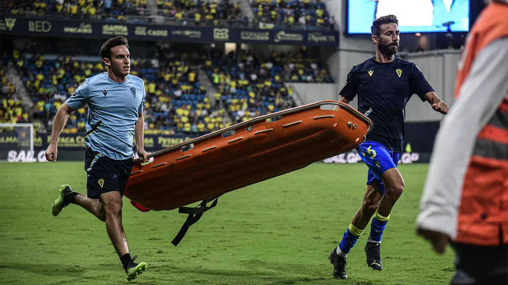 Jose Mari và một nhân viên y tế mang chiếc cáng cứu thương đưa lên khán đài. Ảnh: CGI.