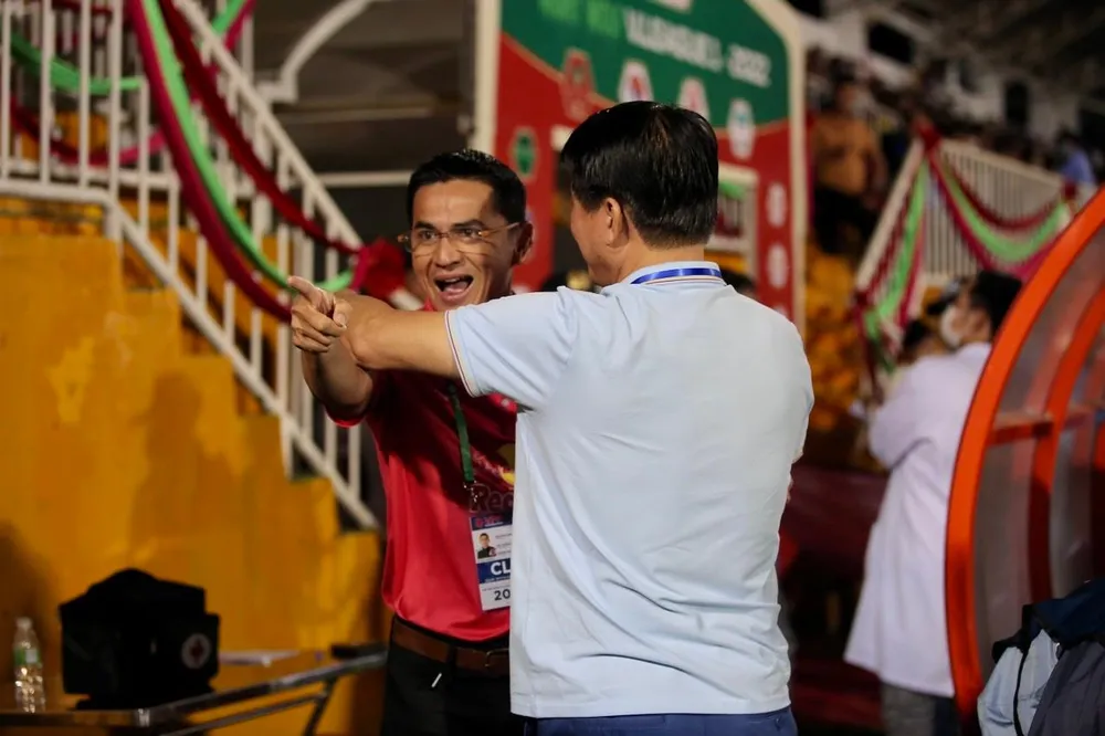 HLV Kiatisak chuyền quả bóng về phía bầu Đức khi nhận câu hỏi về khả năng ông ngồi ghế nóng ở đội tuyển Việt Nam. Ảnh: ANH PHƯƠNG.