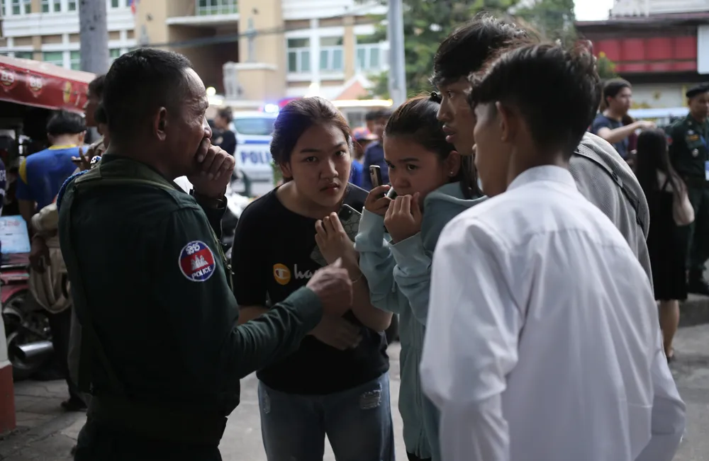 Cảnh sát Campuchia vừa làm nhiệm vụ giữ gìn an ninh trật tự, vừa hướng dẫn các bạn trẻ cách nhận vé miễn phí. Ảnh: ANH PHƯƠNG.