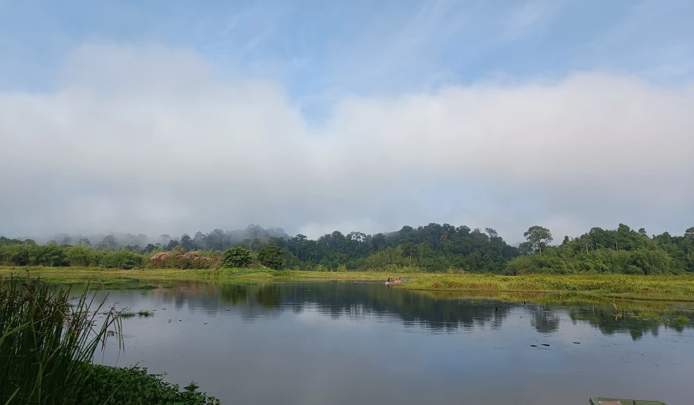 Mặt bàu phẳng lặng trong xanh dưới ánh nắng đầu ngày.