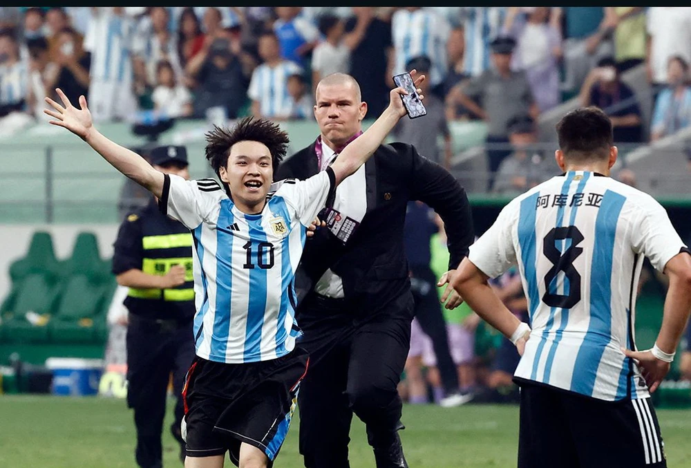 Fan cuồng Messi lao vào sân ở Trung Quốc chạy đến ôm thần tượng. Ảnh: GETTY.