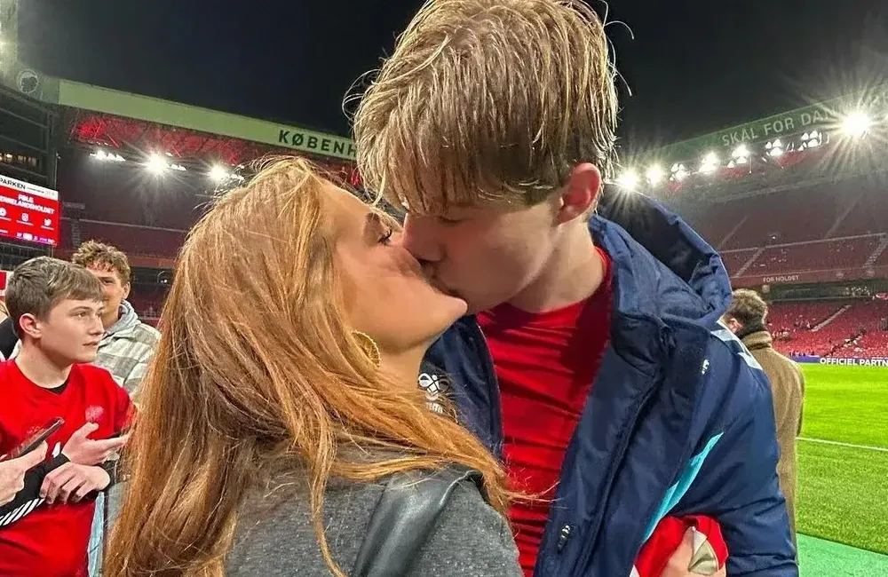 Tiền đạo người Đan Mạch hôn người yêu trên sân bóng sau khi anh lập một hat trick vào lưới Phần Lan. Ảnh: GETTY.