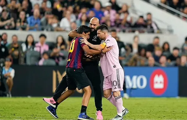 Một fan cuồng chạy vào sân cố tiếp cận Messi nhưng bị vệ sĩ Chueko nhanh tay ngăn chặn. Ảnh: GETTY.