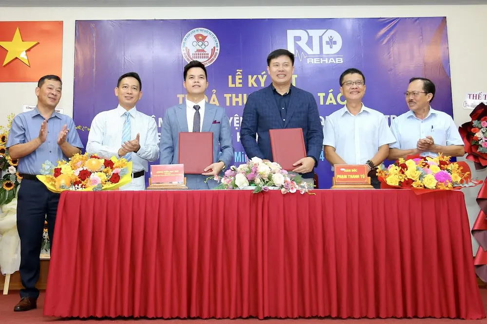Bác sĩ đội tuyển Trần Huy Thọ ký kết hợp tác với Trung tâm 2. Ảnh: ANH ĐỨC. bac-si-doi-tuyen-va-cai-bat-tay-y-nghia-voi-trung-tam-2 (2).jpg