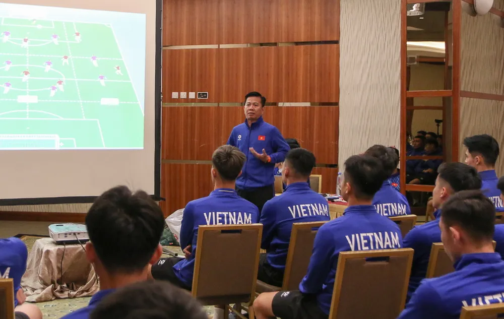 HLV Hoàng Anh Tuấn trang bị kiến thức cho các học trò trước giờ ra trận. Ảnh: AN. nong-4-cau-thu-u-23-viet-nam-bi-loai-ve-nuoc (1).jpg