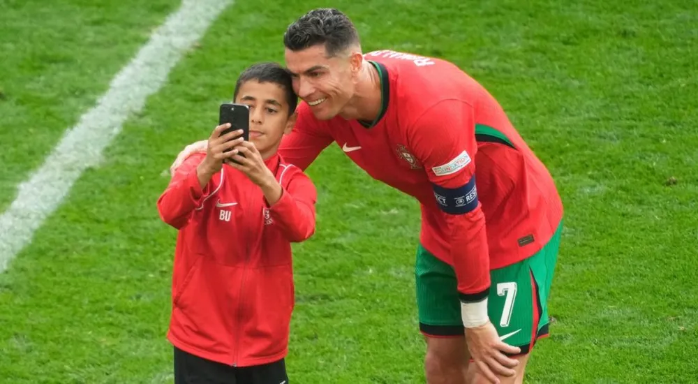 Ronaldo thân thiện với một cậu bé chạy xuống sân để selfie với thần tượng của mình. Ảnh: GETTY. hlv-martinez-lo-so-ronaldo-bi-tan-cong (2).jpg