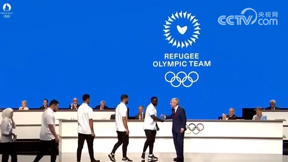 Chủ tịch IOC Thomas Bach chào đón các vận động viên EOR. Ảnh: GETTY. co-mot-doi-tuyen-olympic-nguoi-ti-nan-dac-biet-o-paris-2024 (1).png