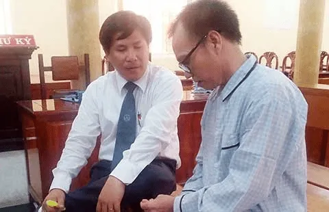 Bị cáo Nguyễn Tấn Khoa (phải) đang trao đổi với luật sư tại phiên tòa. Ảnh: LỆ TRINH đình chỉ vụ án