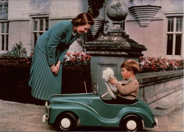 Công chúa Elizabeth nhìn con trai mình là Thái tử Charles chơi trong chiếc ô tô đồ chơi của mình. Ảnh: Motorbiscuit.