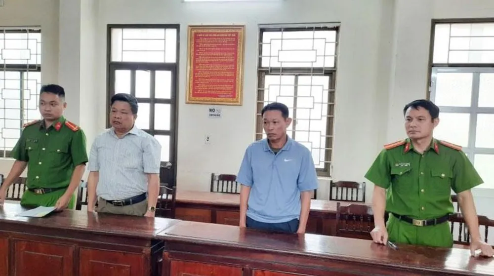 Bị can Ngô Xuân Khải (áo kẻ trắng) và Nguyễn Đức Trường (áo xanh) bị khởi tố về tội lợi dụng chức vụ quyền hạn trong khi thi hành công vụ. Ảnh: CTV