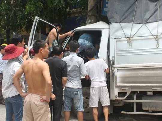Người dân dùng xà beng giải cứu tài xế, phụ xe mắc kẹt trong cabin. Người dân dùng xà beng giải cứu tài xế, phụ xe mắc kẹt trong cabin.