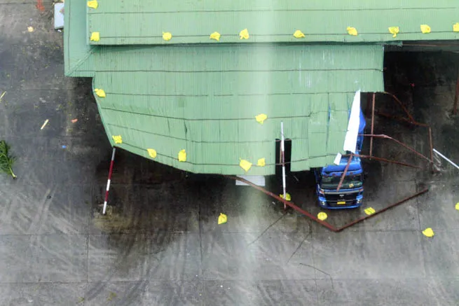 Bão làm sập mái tôn đè vào một xe tải.