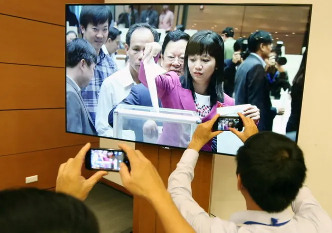 Phóng viên tác nghiệp Quốc hội bỏ phiếu tín nhiệm qua màn hình tại trung tâm báo chí Quốc hội - Ảnh: Việt Dũng