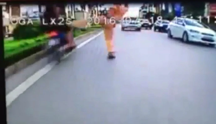 Hình ảnh CSGT dơ chân khiến người vi phạm ngã ra đường (ảnh cắt từ clip)