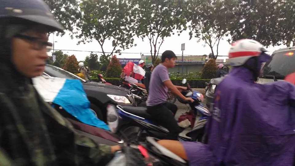 Mưa đổ xuống, người chạy xe máy ùn ùn dừng lại mặc áo mưa, ngay trong làn đường ô tô, và kẹt xe (đường Trường Chinh). Ảnh: Lâm Thông