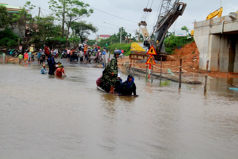 Người và phương tiện được chở qua đoạn ngập bằng xe bò