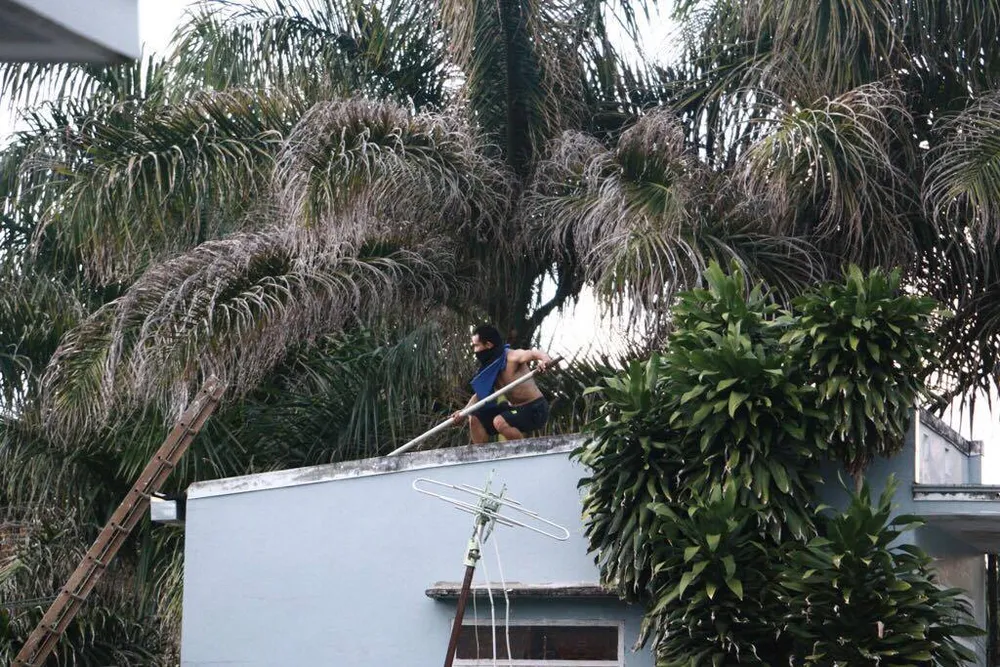 Thanh niên ngáo đá tay cầm hung khí đứng một tòa nhà cao tầng