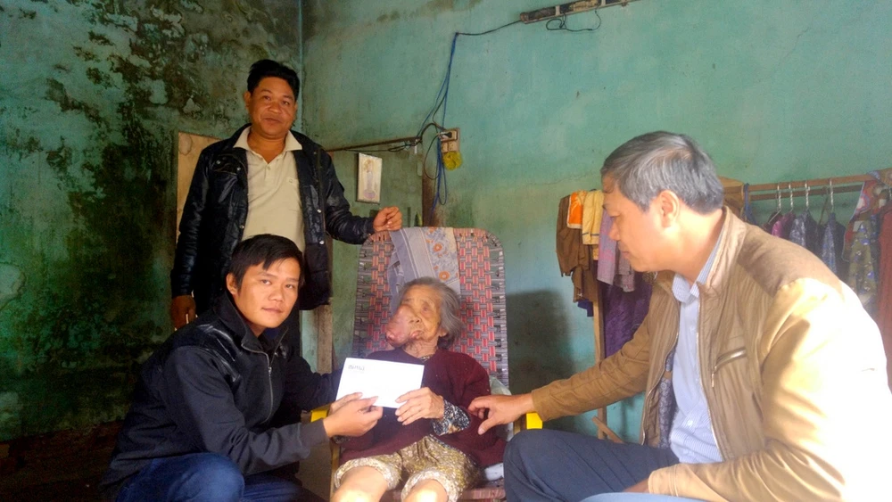 Cụ bà Trần Thị Minh (Quảng Nam) nhận 5 triệu đồng tiền hỗ trợ. Ảnh Huy Trường